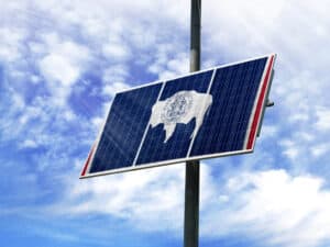 Solar panels against a blue sky with a picture of the flag State of Wyoming