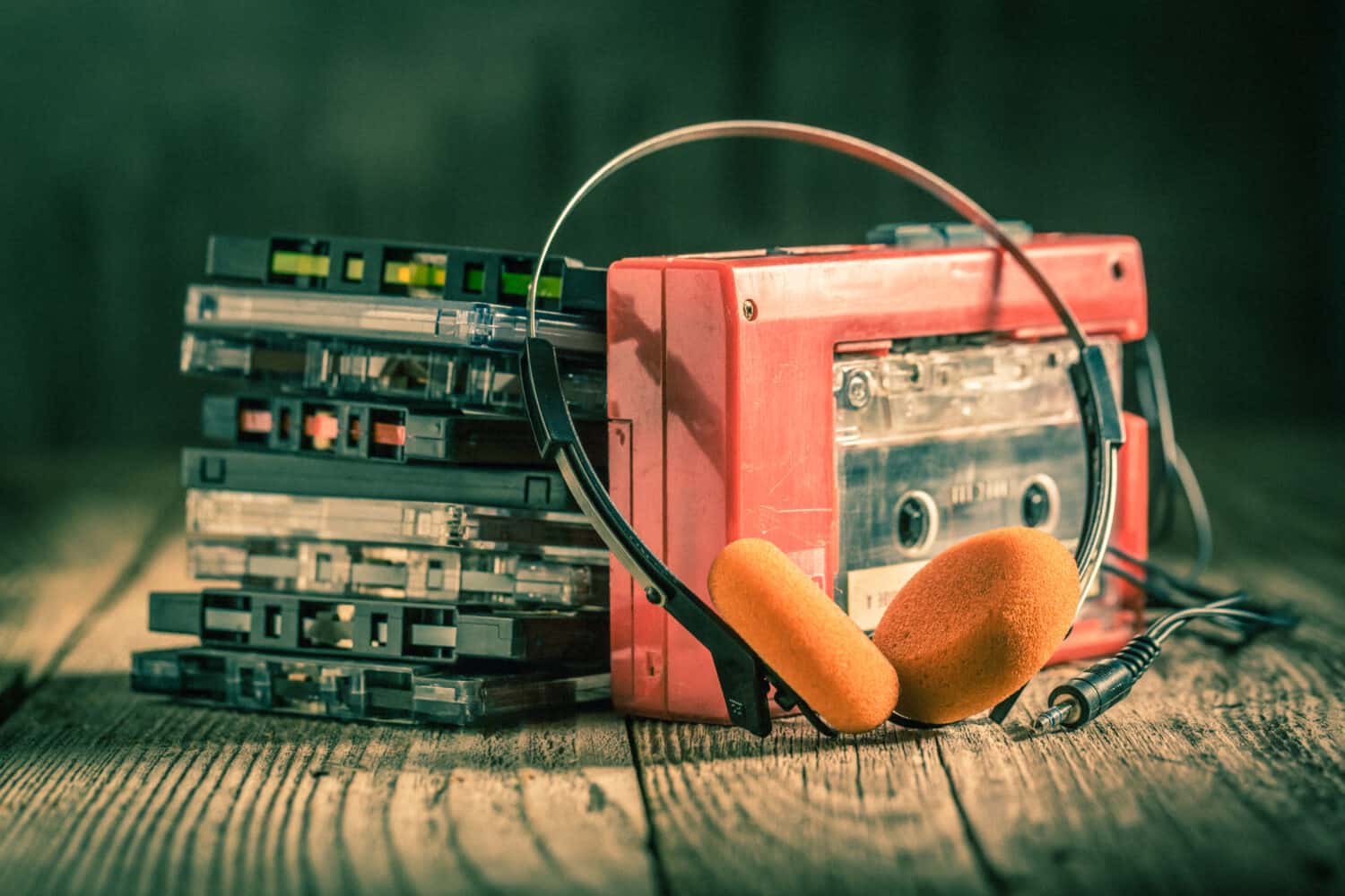 Closeup of cassette tape, red walkman and headphones