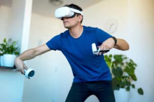 Young men playing a virtual reality game at home using a VR headset
