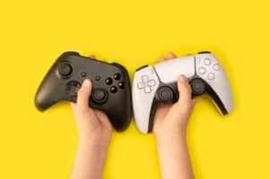 Kid holding game controllers in yellow background