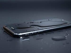 Close-up of an old telephone in water on a black background. Wet smartphone.