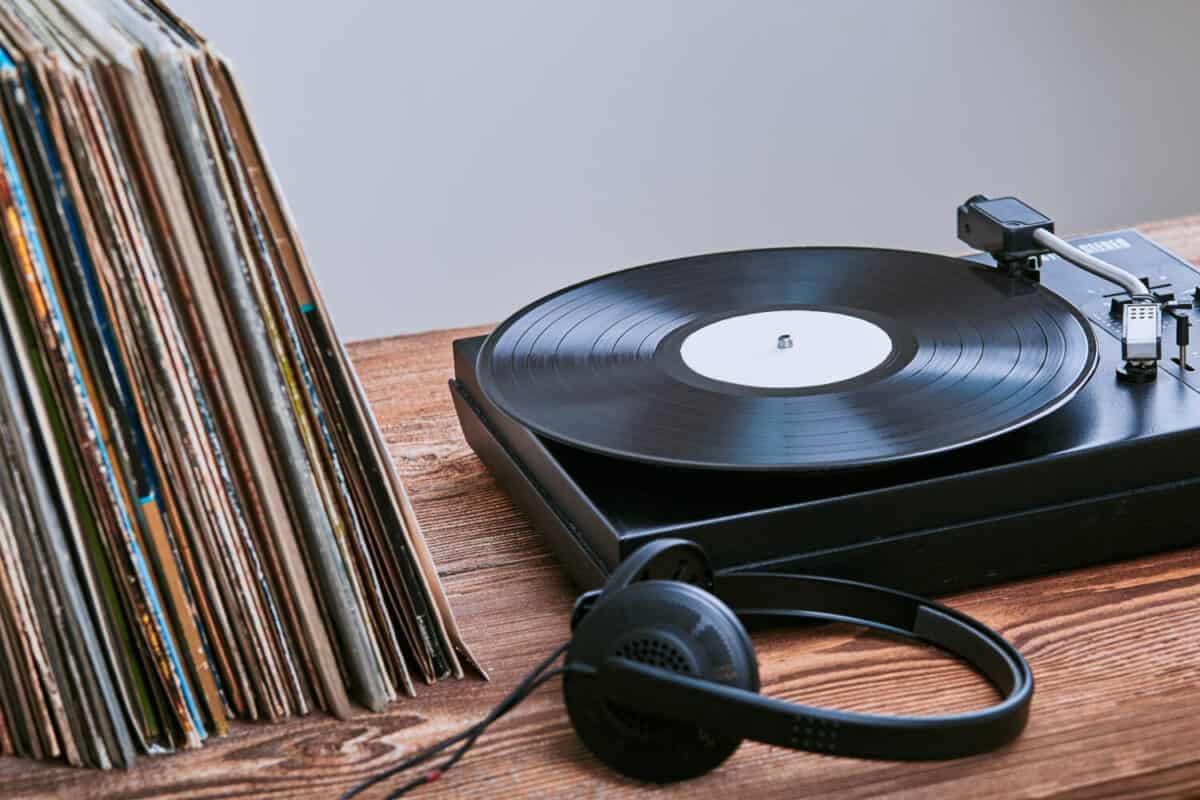 Stack of black vinyl records, turntable vinyl player and headphones. Classic stereo set. Candid people, real moments, authentic situations