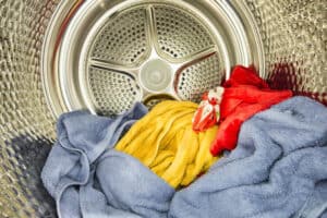 Interior view of tumble dryer with drying clothes. Conceptual image of housework and doing laundry.