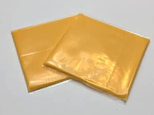 Two Kraft singles cheese slices in the individual wrapping