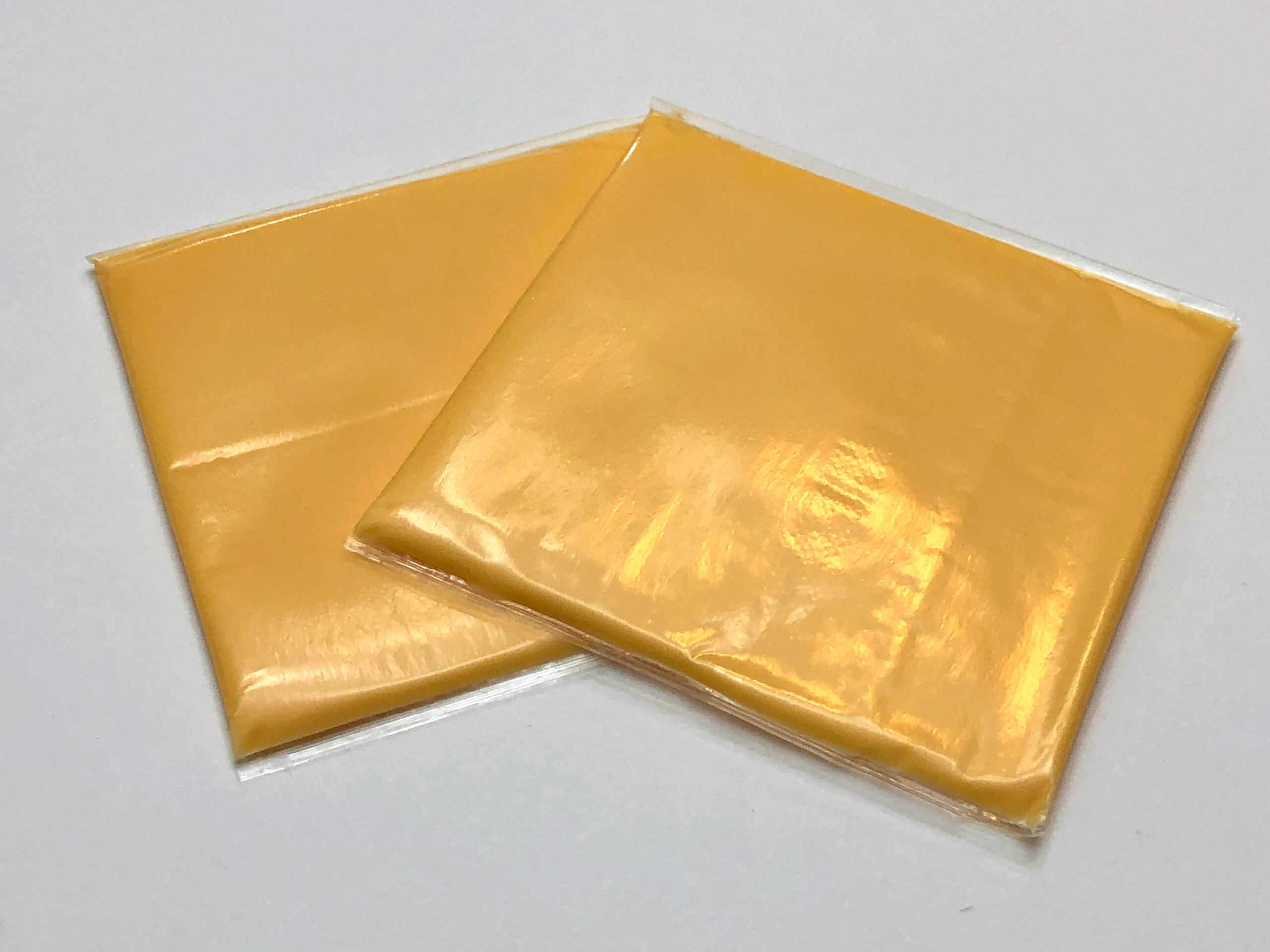 Two Kraft singles cheese slices in the individual wrapping