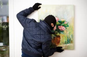 Thief stealing the piece of art from gallery of art.