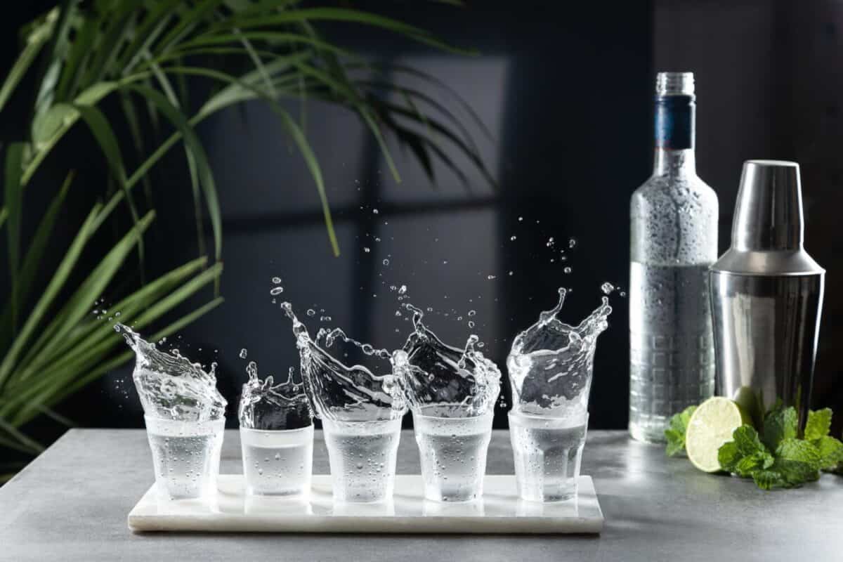 Vodka splash in shot glasses at the bar.