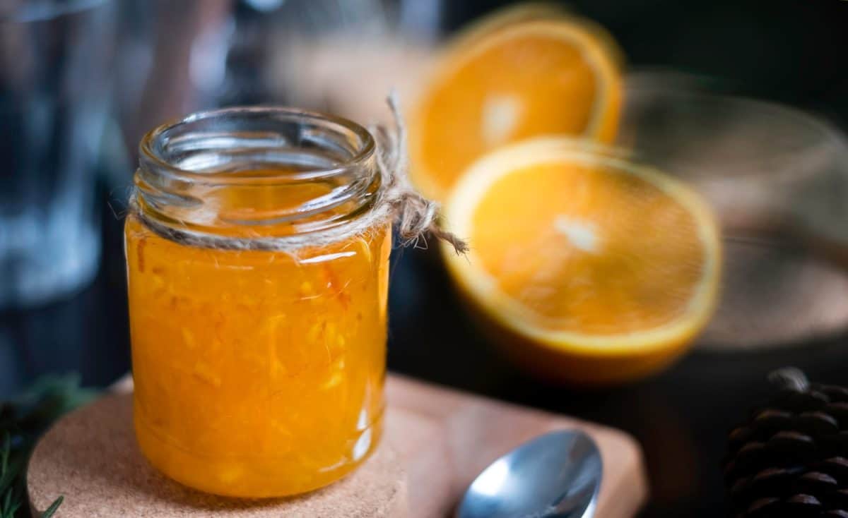 Orange marmalade / orange jam in glass jar. A confiture is any fruit jam, marmalade, paste or fruit stewed in thick syrup. Orange marmalade & fruit jam in glass jar concept. Dark food photography.