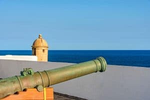 Old iron cannon and guardhouse on the strong walls of the historic fortress of Farol da Barra in the city of Salvador, Bahia