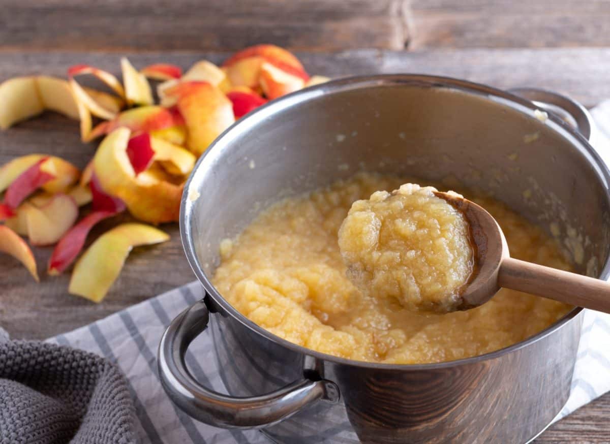 Homemade applesauce in a pot with wooden spoon