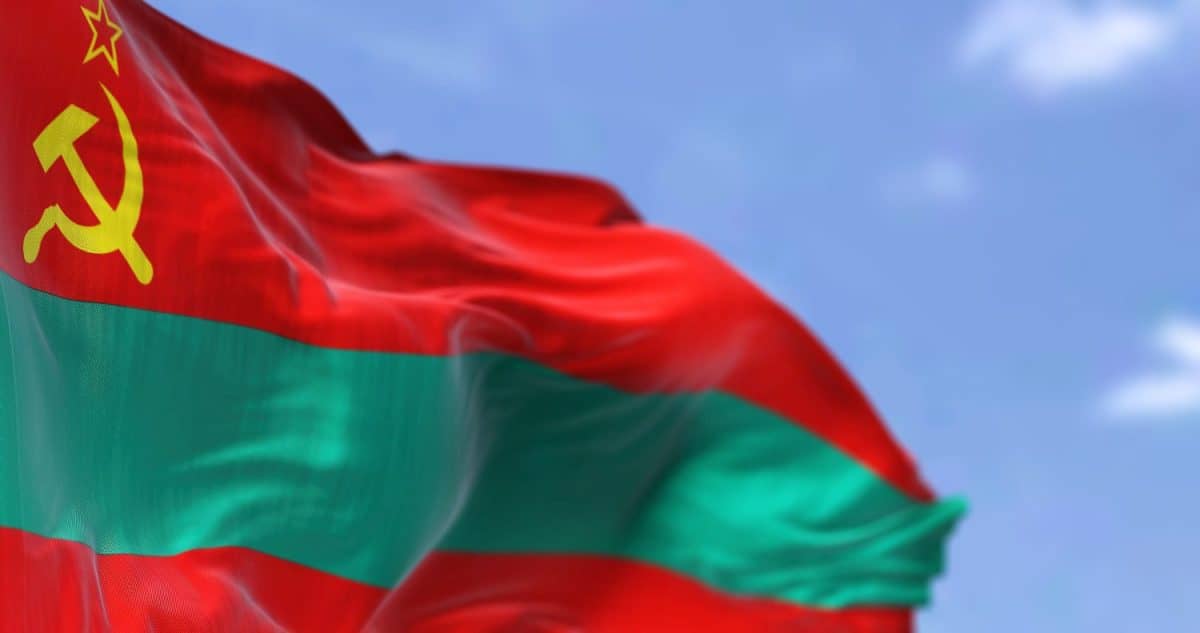 Close-up side view of the national flag of Transnistria waving in the wind. In the background a clear sky. Patriotism and pride. Selective focus