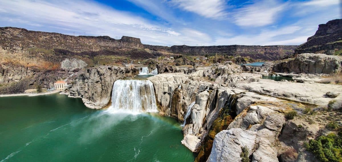 Shoshone Falls Reservoir in Twin Falls, Idaho. Wide angle view of the water flowing over the stone cliffs with a view of the dam and table rocks in the background.