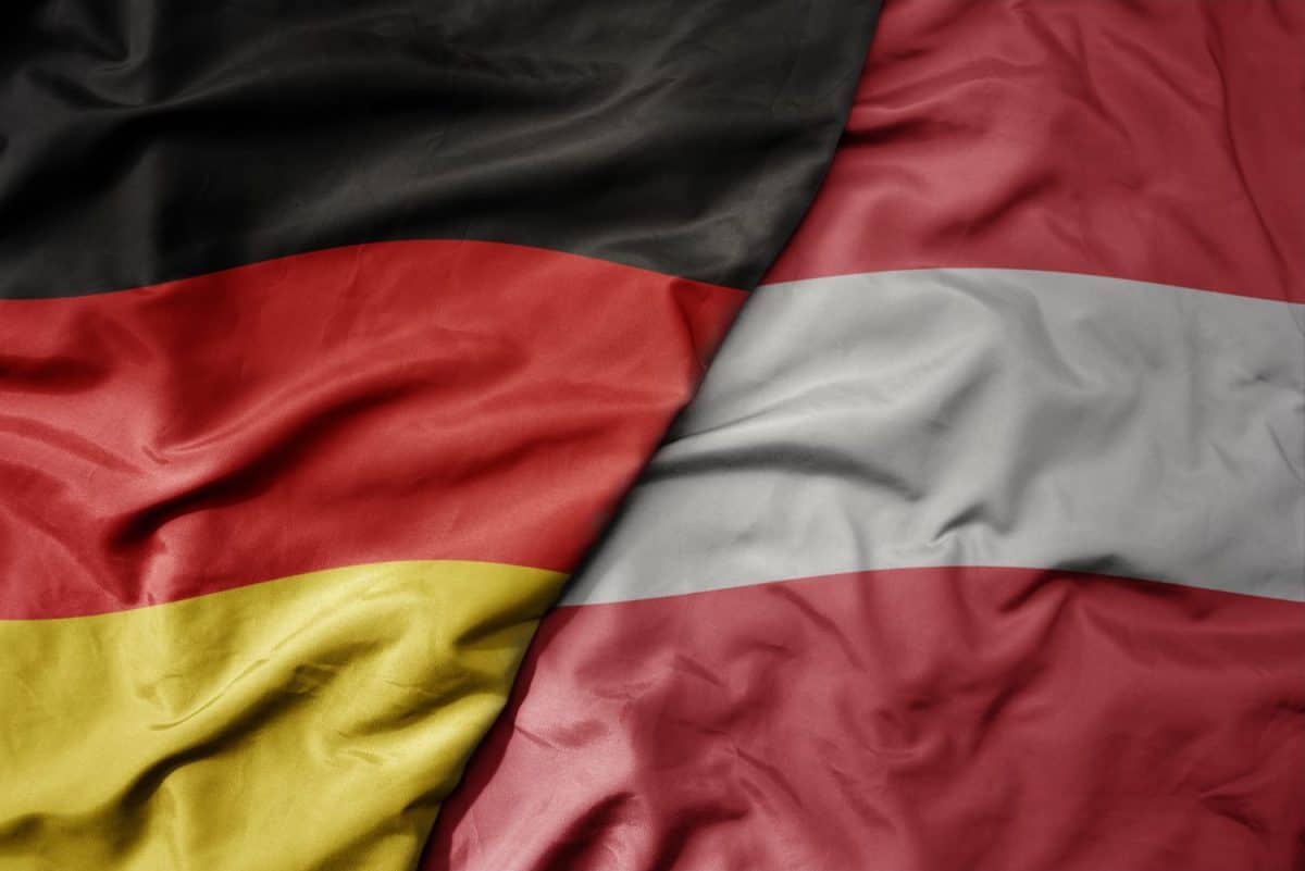 big waving realistic national colorful flag of germany and national flag of austria . macro
