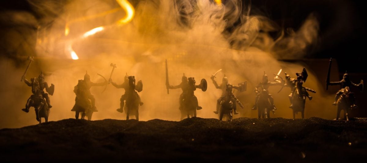 Medieval battle scene. Silhouettes of figures as separate objects, fight between warriors at night. Creative artwork decoration. Foggy background. Selective focus