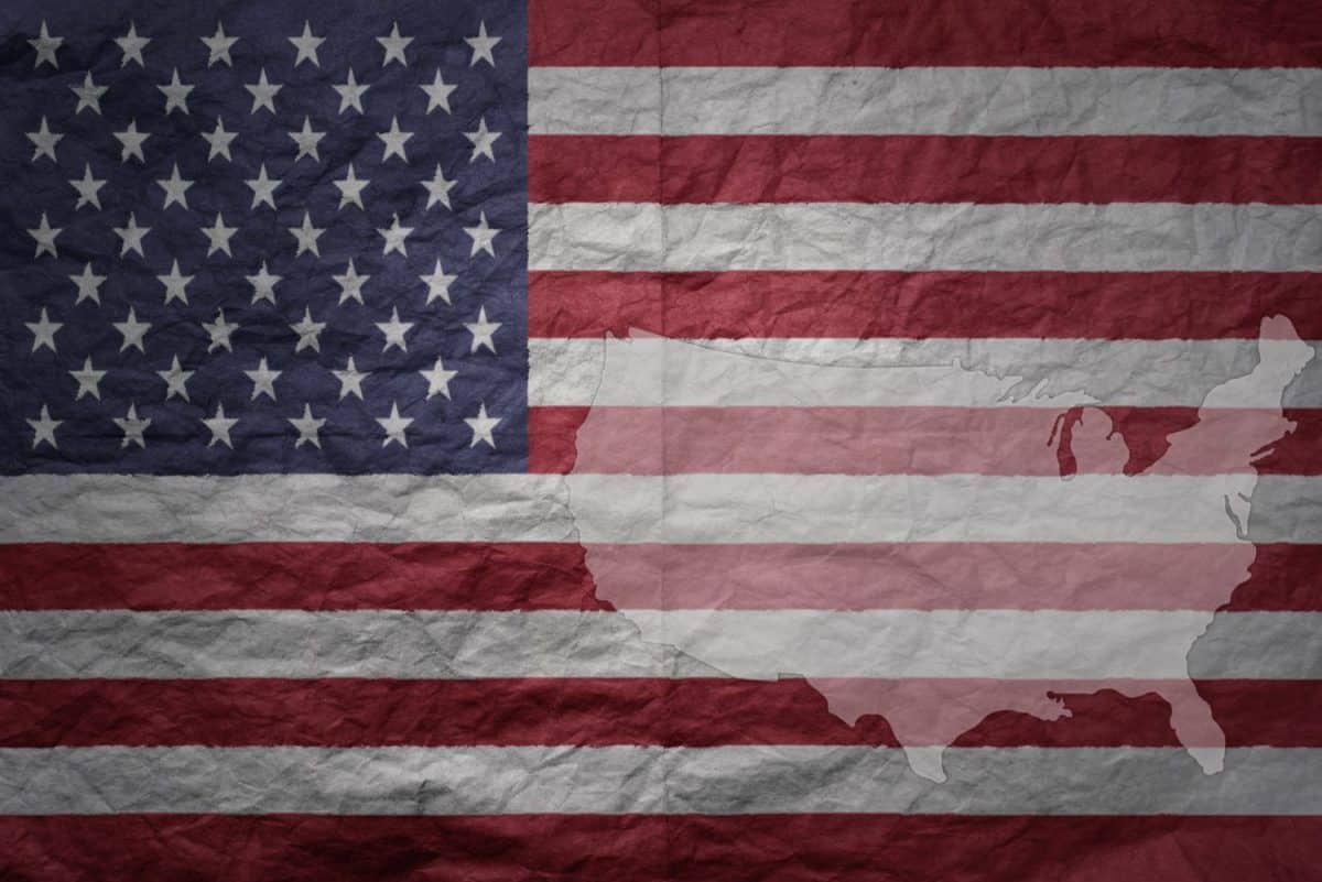 colorful big national flag and map of united states of america on a grunge old paper texture background