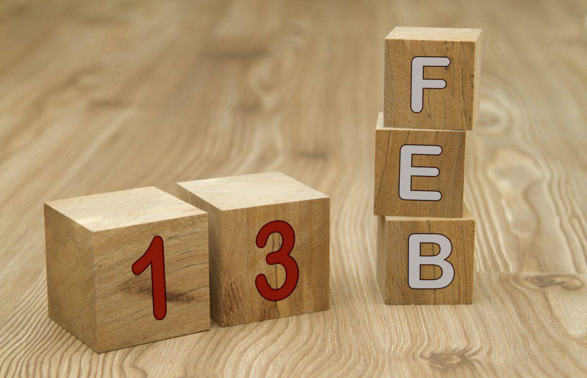Cube shape calendar for February 13 on wooden surface with empty space for text.