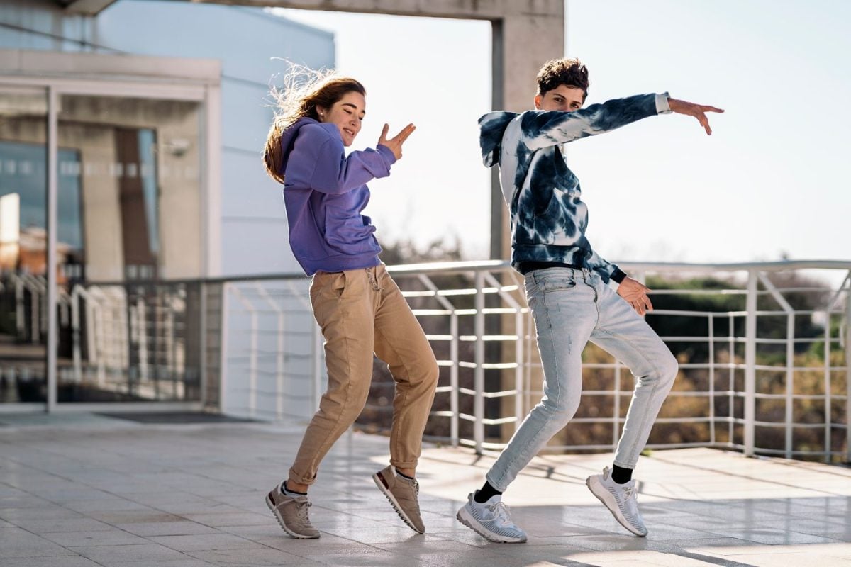 Stock photo of cool girl and her friend doing dance moves and having fun.