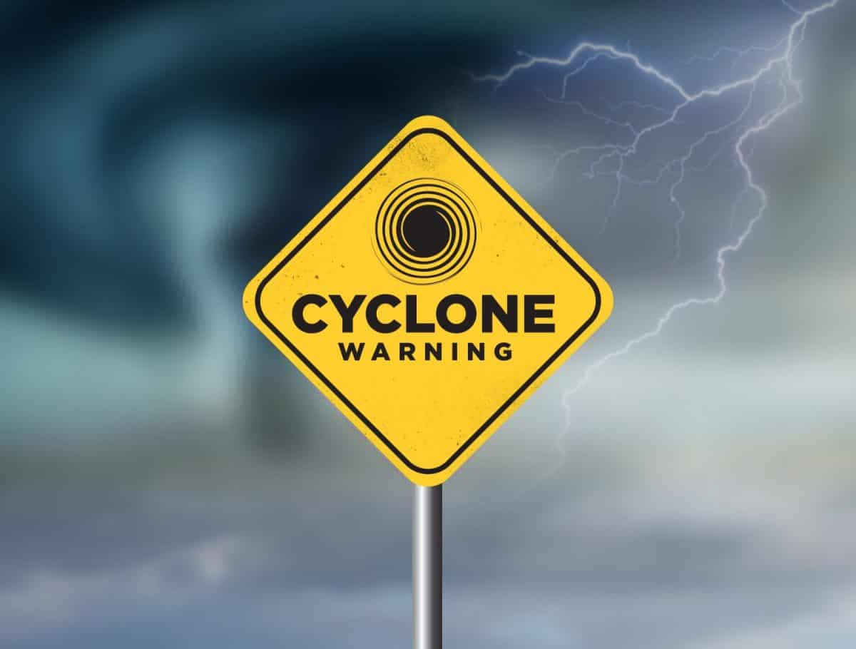Cyclone warning sign against a powerful stormy background with copy space. Dirty and angled sign with cyclonic winds add to the drama.