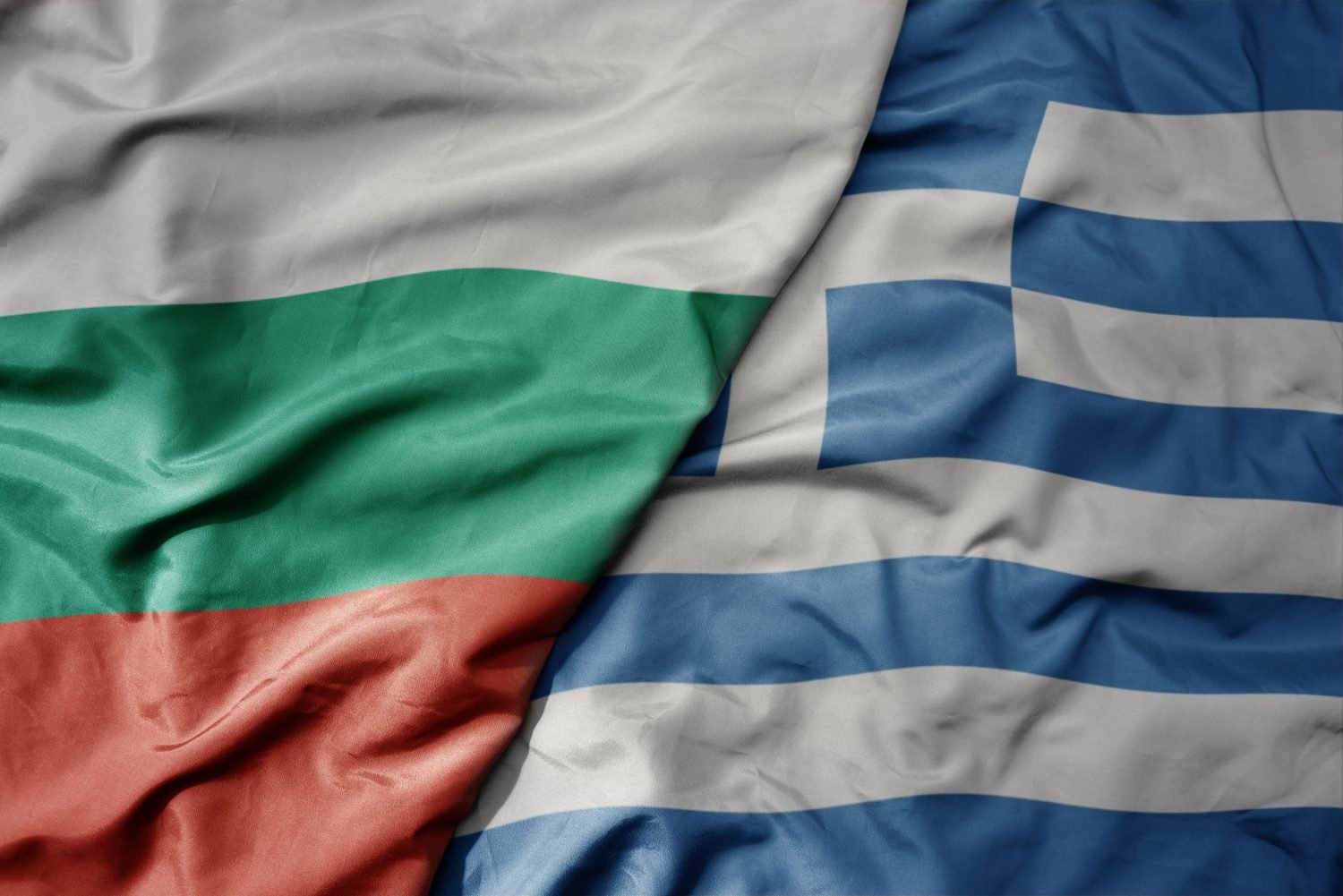 big waving national colorful flag of bulgaria and national flag of greece . macro
