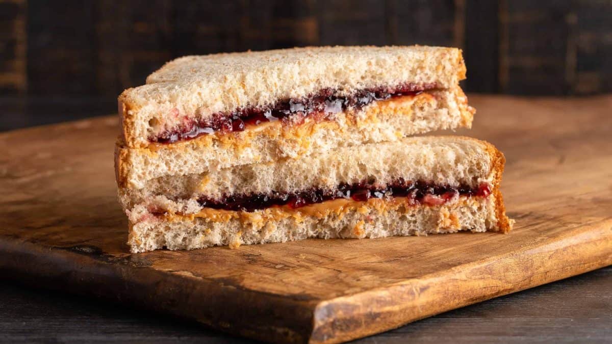 A Peanut Butter and Grape Jelly Sandwich on a Wooden Cutting Board