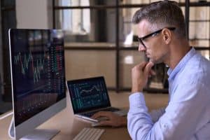 Crypto trader investor analyst broker using pc computer analyzing digital cryptocurrency exchange stock market charts graphs thinking of investing funds risks in trading platform global analytics.