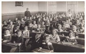 Antique portrait of school classmates. Group of children and teachers. Vintage picture with original film grain and blur