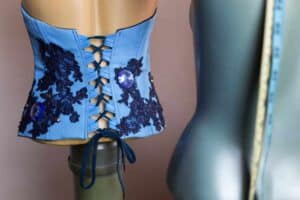 Beautiful blue corset on tailor's dummy. Another dummy in the front with measurement tape. Making of prom dress. Fashion design concept