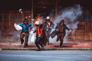 Cowboys group showing action success bank rob with fighting gun and a lot of  money from rob the bank with white smoke vintage style background