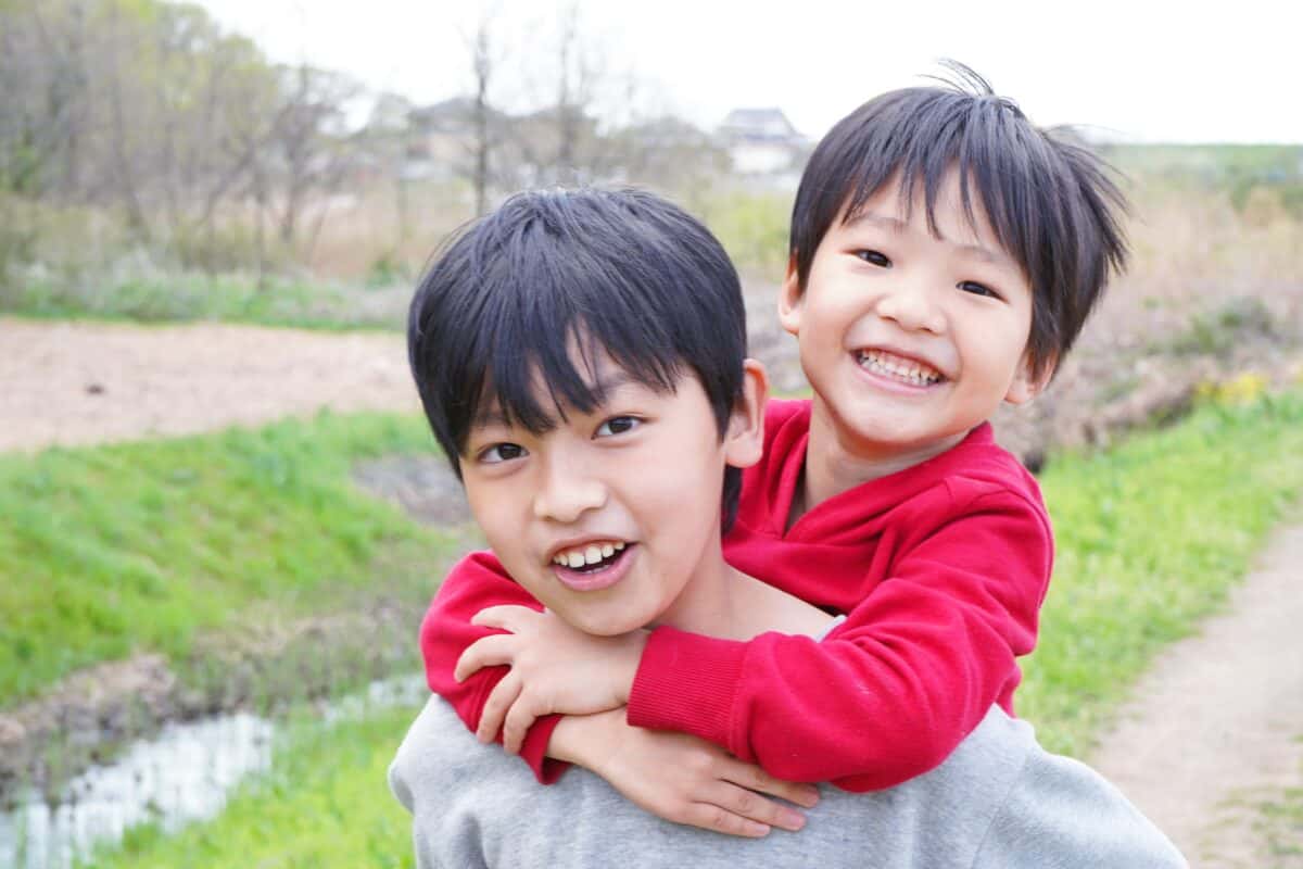 Good friends laughing happily while riding on their backs